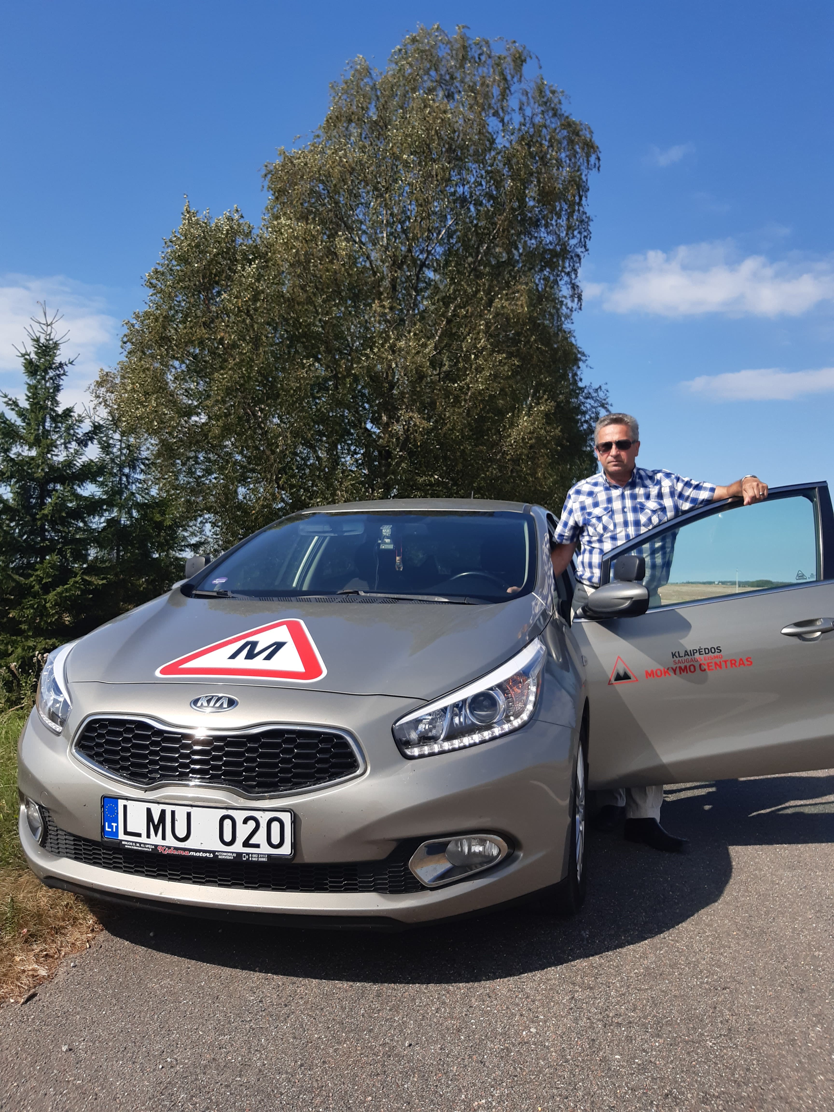 Instruktorius Arvydas prie mokomojo automobilio